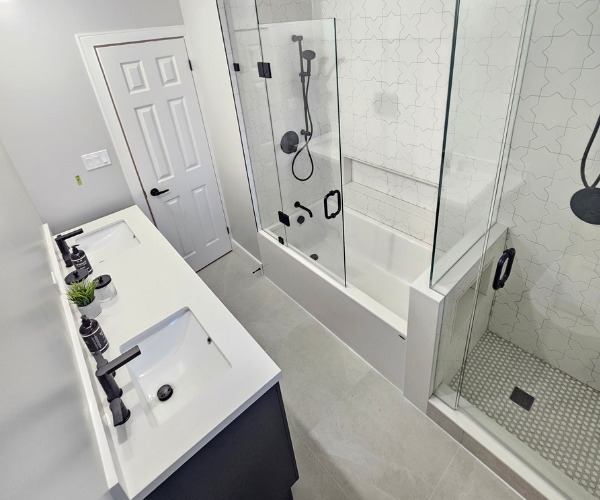 Custom dual-sink bathroom vanity and glass shower renovation by Master Plumber Brian Noble.