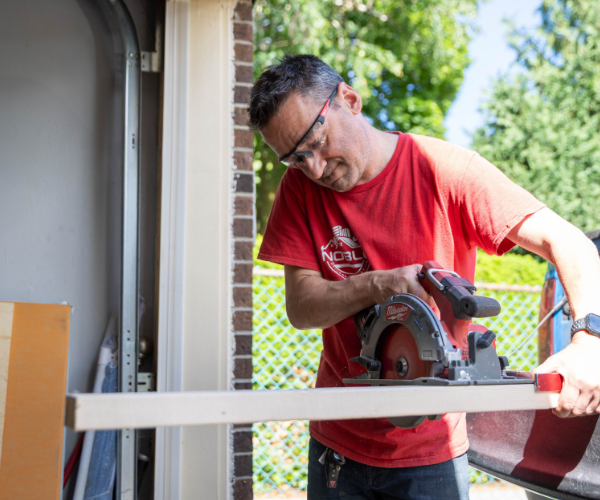 Brian Noble cutting a wood board with a circular saw Brian Noble cutting a wood board with a circular saw
